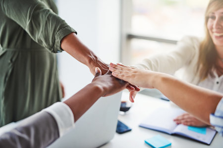 Because teamwork makes the dream work. unrecognizable businesswomen piling their hands on top of...