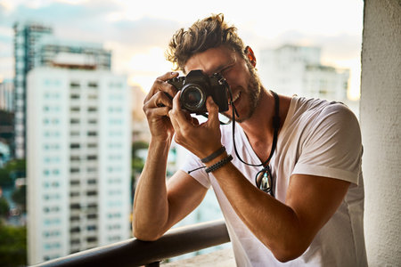 Change the way you look at things. a young man taking photographs of the city with a camera outside.