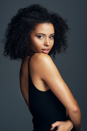 Effortlessly beautiful. Studio shot of a beautiful young woman posing against a dark background.の写真素材