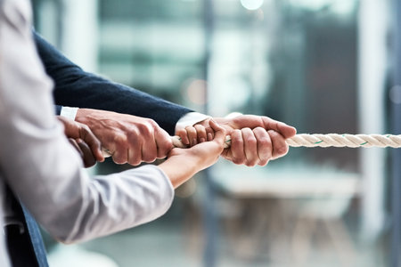 Reeling in their next big success. Closeup shot of businesspeople tugging on a rope in an office.の写真素材