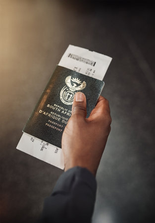 What I need to see the world. POV shot of an unrecognizable man holding his passport and boarding pass in an airport.の写真素材