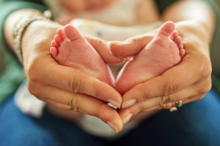 So tiny and so precious. Closeup shot of a mother holding her babys tiny feet in her hands.の写真素材