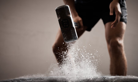 Workout, dust and hands hammer tire in studio isolated on a brown background mockup. Sports, fitness and male, athlete or man hammering tyre with chalk powder for training, exercise and muscle power.の写真素材