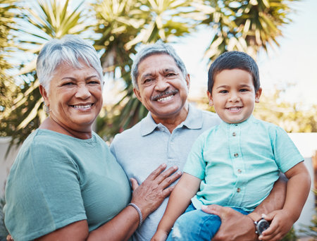 Grandparents, child and portrait outdoor in a garden with love, care and kid support. Smile, happy and Mexican family together with kid and senior people in sunshine in a park with children in natureの写真素材