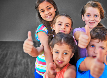 Yes you can. Studio shot of a diverse group of kids showing thumbs up against a gray background.