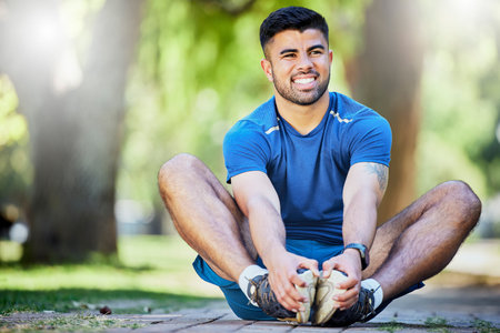 Fitness, exercise and a man stretching outdoor at park for cardio workout, training and muscle warm...