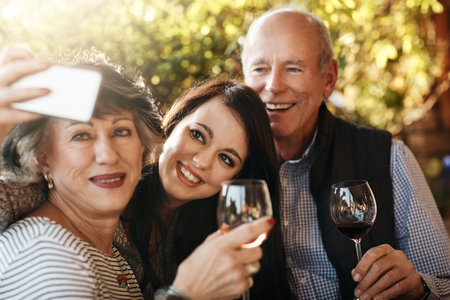 Spending some time with my parents. an attractive young woman taking a selfie with her parents on...