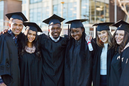 Were going to keep on succeeding throughout life. Portrait of a group of students standing together on graduation day.の写真素材