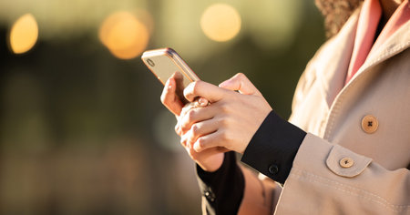 Hands, communication or business woman with phone for networking or social media in London street....