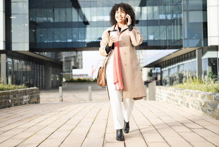 Phone call communication, walking and happy black woman networking, talking and on 5g conversation in New York. Urban architecture, sales agent or relax employee on morning commute to office buildingの写真素材