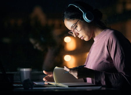 Headphones, research and girl student studying at night for a test, exam or college assignment....
