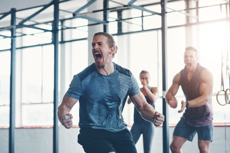 Im unbeatable. a fitness group celebrating a victory at the gym.
