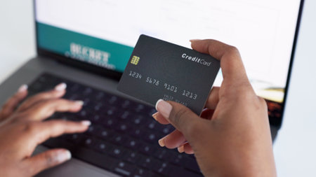 Ecommerce, credit card and typing on laptop while doing online shopping with fintech technology with closeup of woman hands. Paying bills, order and internet banking with secure wifi connectionの写真素材