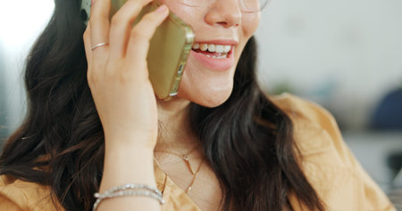 Phone communication, talking and asian woman at home on a sofa with a online conversation. Phone call, speaking and networking of a person on a mobile phone at a living room house on a couchの写真素材