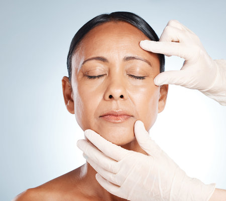 Botox, mature woman and doctor hands check face for plastic surgery and beauty consultation....