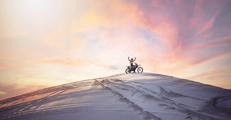 Desert, sunset and man riding a motorcycle for exercise, fitness or skill training in nature. Extreme sports, dusk and male athlete on a bike for an outdoor evening workout in the sand dunes in Dubaiの写真素材