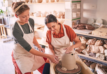 Pottery wheel, workshop support and women doing sculpture design mold, studio manufacturing or art product. Creative, vase molding and startup small business owner, artist or friends in ceramic storeの写真素材