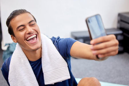 Fitness, man and laugh for selfie, social media or profile picture with towel after workout exercise or training at gym. Happy sporty male vlogger or influencer laughing in happiness for vlog postの写真素材