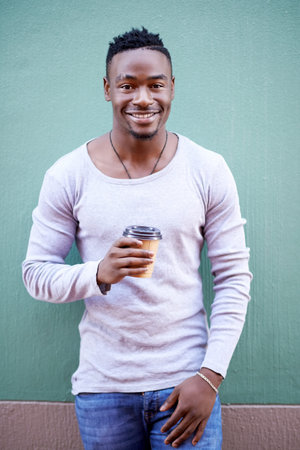 You cant say coffee without a smile. a handsome young man out in the city.