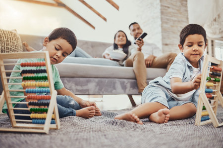 Math, family or children learning for development growth with mother and father relaxing watching tv. Education, siblings or young boys playing fun toys or counting games for kids at home togetherの写真素材