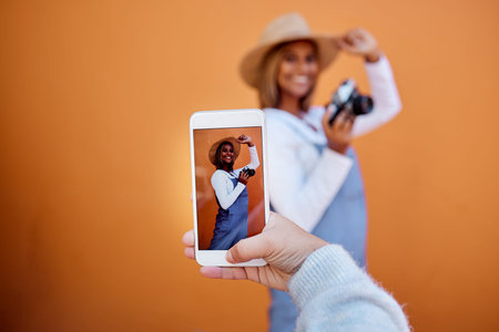 Friends taking picture on a phone of woman isolated on wall background on social media or digital...