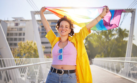 Portrait, pride and lesbian woman with flag on city bridge, lgbtq community, identity with support and equality in love Rainbow, lifestyle and lgbt awareness, inclusion and celebrate with sexualityの写真素材