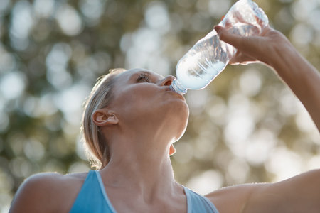 Nothing is more refreshing than water. mature and fit woman having a drink from a water bottle in...