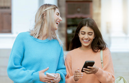 Friends, women laugh at meme on smartphone, social media and students on campus, outdoor and comedy online. Connection, funny post and 5g network, communication and technology with Gen z youthの写真素材