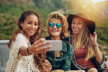 Its so beautiful out here. a group of friends taking a selfie while on a roadtrip together.