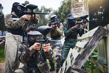 Paintball, military team and shooting training of friends and soldier group with gun. Target exercise, sport game and weapon sports of army men in camouflage together for outdoor games in uniformの写真素材