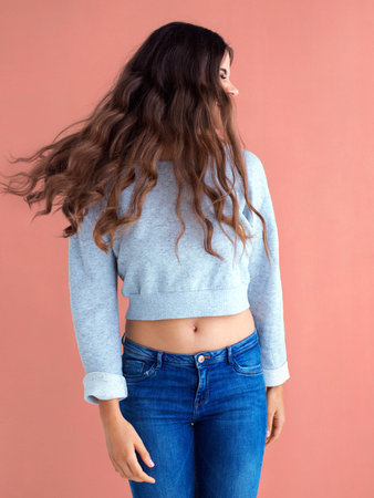 How beautiful is her long brown hair. Studio shot of a beautiful young woman posing against a pink...