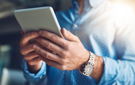 Everything at the touch of a button. an unrecognizable young designer using his digital tablet in...