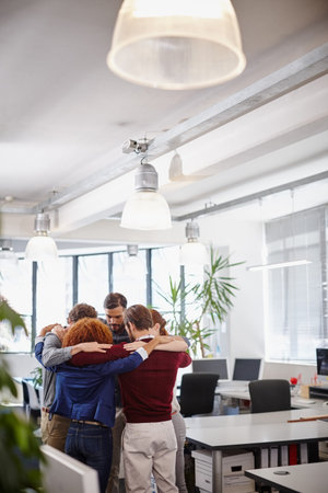 Psyching themselves up for the next challenge. a team of businesspeople forming a huddle in the...