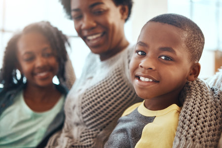 Love, portrait of mother and children bonding on sofa for happy family time together in apartment in South Africa. Smile, trust and support, black woman and kids on couch with healthy relationship.の写真素材