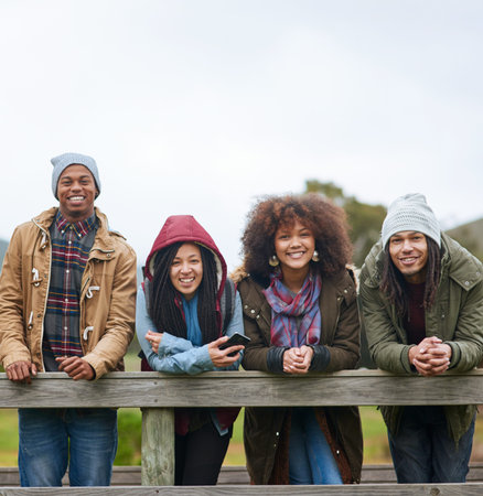 Getting out of town for the weekend. Portrait of a group of friends posing on a wooden bridge...