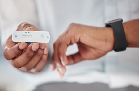 Covid, rapid test and hands of person with watch for time check with healthcare assessment in pandemic. Corona pcr and result of black man with medical exam kit at hospital or virus clinic zoom.の写真素材