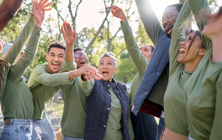 Team celebration, hands in air and volunteer group in nature with diversity and happiness. Community...