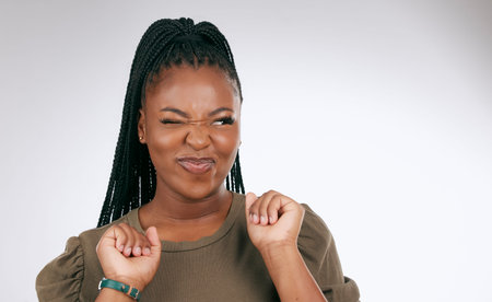 Silly, happy and black woman face with sassy emoji attitude facial expression in studio. White...