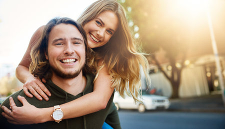 She brings out the fun side of me. Portrait of a happy young couple enjoying a piggyback ride in the city.の写真素材