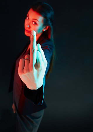 Do you speak sign language. Portrait of a rude businesswoman showing her middle finger against a...