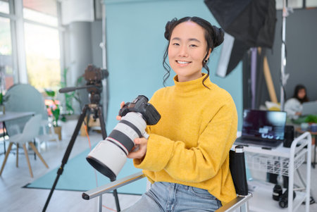 Happy, photoshoot and portrait of a photographer with a camera for production, video and media. Creative, smile and an Asian woman in a studio for filming, shooting and working in photographyの写真素材