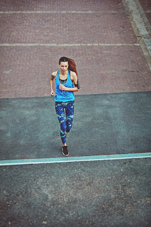 Go farther. a young woman out in the city for her morning run.
