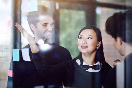 This is what Ive come up with. a group of businesspeople working on a glass wall the office.
