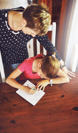 Teaching from home. High angle shot of a cheerful mother and daughter doing homework together at the...