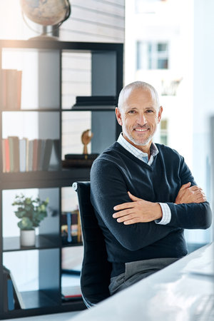 Happiness is the secret ingredient for successful businesses. a mature businessman in his office.