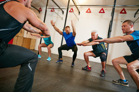 Extend your arms and squat. a trainer demonstrating a squat workout at the gym.