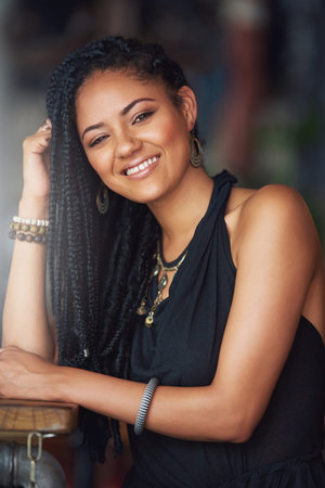 Feeling content in the coffee shop. Cropped portrait of an attractive young woman sitting in a coffee shop.の写真素材