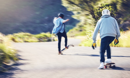 Friends, speed and longboard skating in road, men racing downhill with skateboard and helmet for safety. Extreme sports adventure, skateboarding street race and skateboarder tricks on mountain pass.の写真素材
