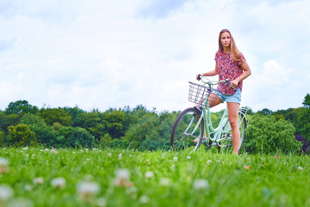 Getting to know Mother Nature on her bicycle. a young woman cycling in the countryside.の写真素材