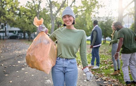 Plastic bag, park and happy woman in cleaning portrait for earth day, community service or volunteering support. Recycle, trash or garbage goals of ngo person helping in nature or forest pollutionの写真素材